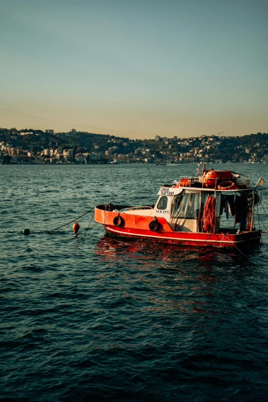 a large red boat floating on top of a body of water