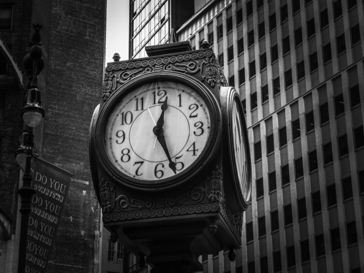 a black and white image of a clock tower in the city