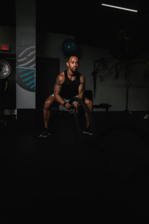 a man with tattoos lifting dumbbells and a bar