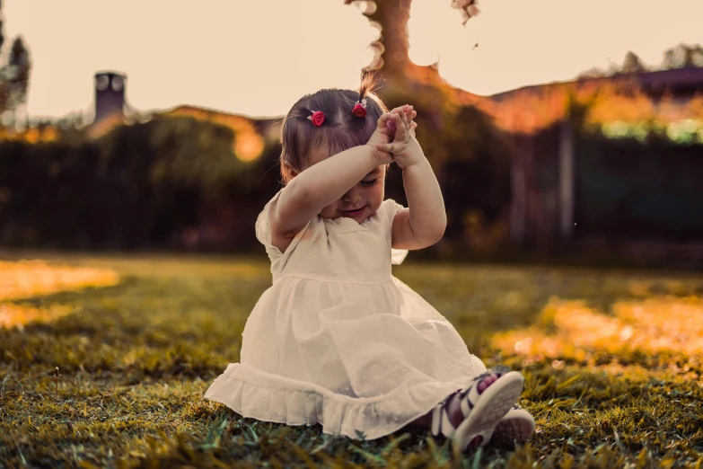 a  in a dress sitting on the grass