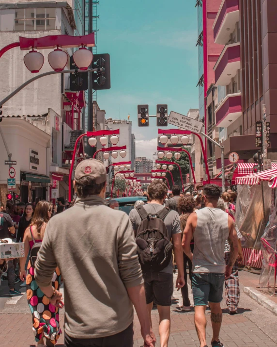 pedestrians walk through a city street near red traffic lights