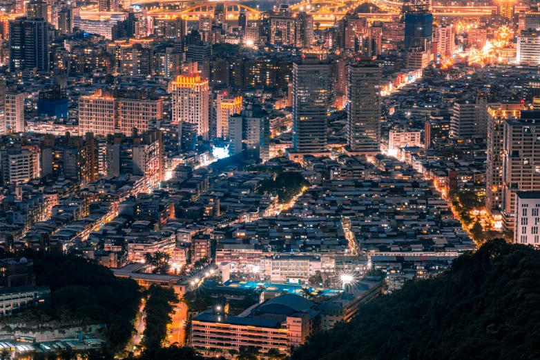 a cityscape is lit up at night as a view of the surrounding hills