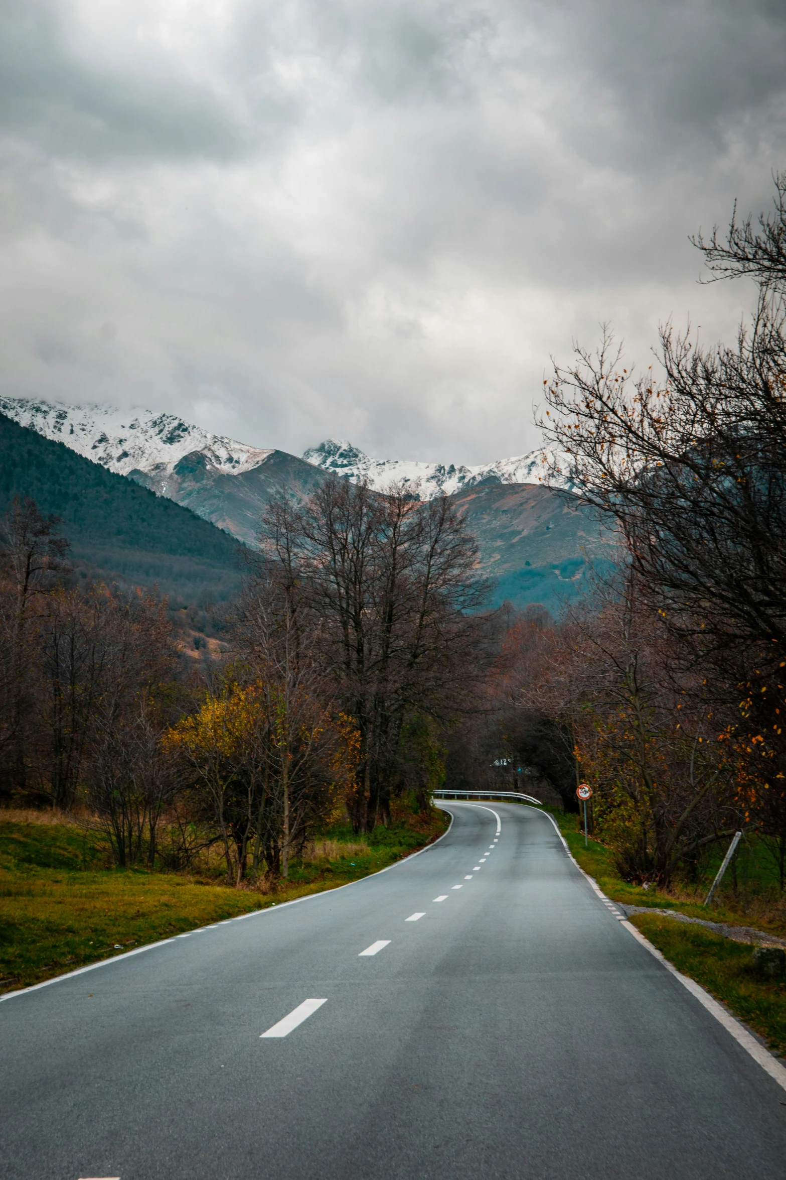 a road leading to the mountains under a stormy sky