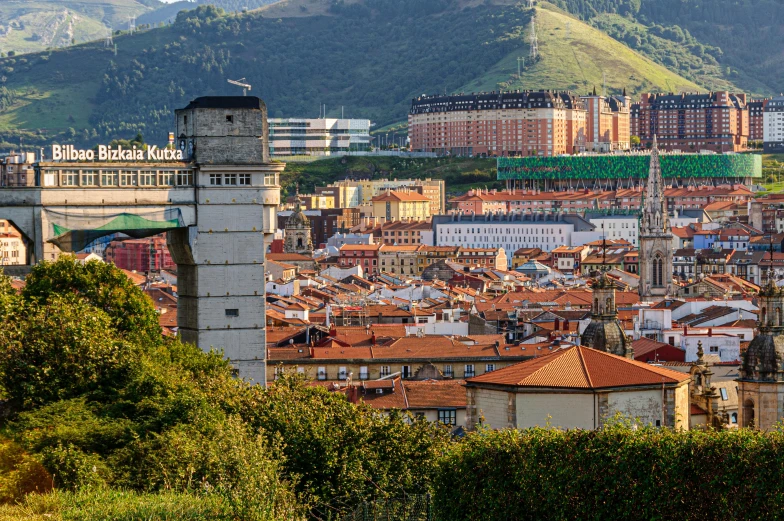 some buildings in the background and hills behind them