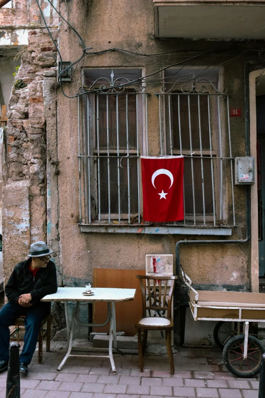 a man sitting at a table in front of an apartment