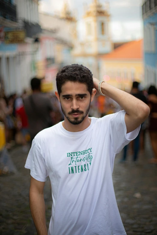 a man wearing a t - shirt and a ring is holding his head