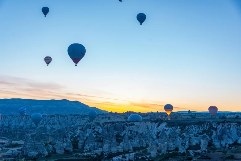 a group of balloons that are flying over the ground