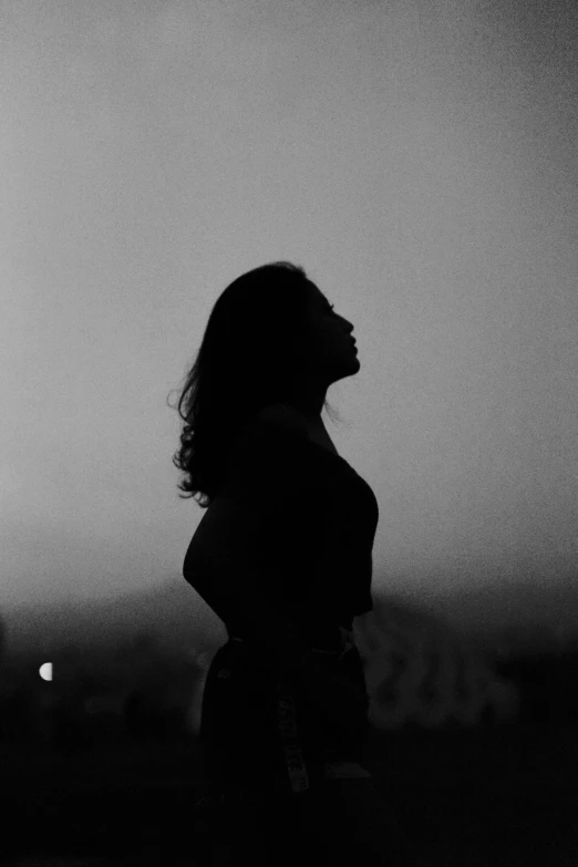 black and white pograph of woman in silhouette facing away