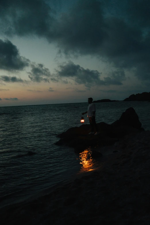 the person with a lit candle is looking at the water