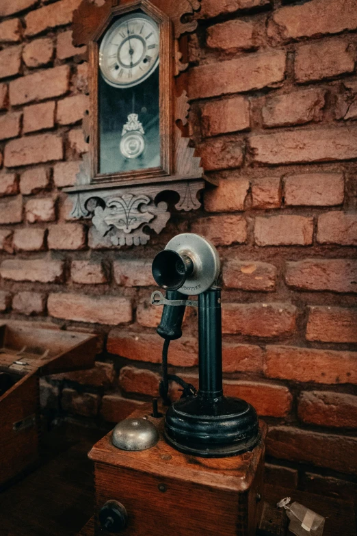 an old metal machine sitting in front of a red brick wall