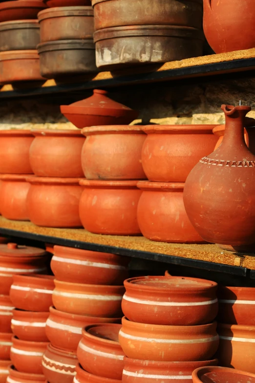 orange terracotti pots are lined up on shelves