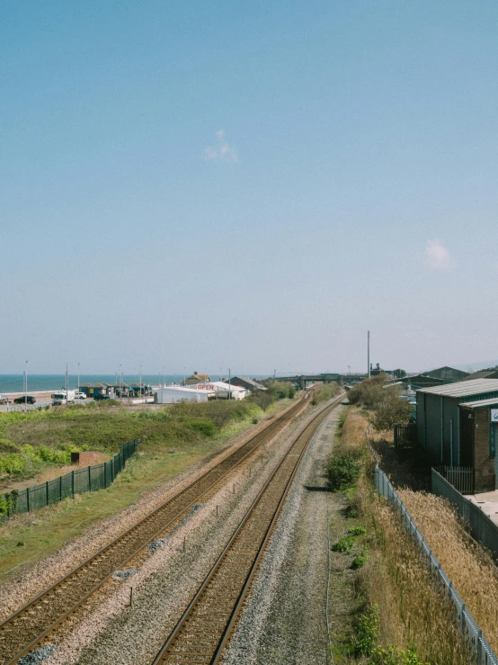 a beach with two tracks running next to a building