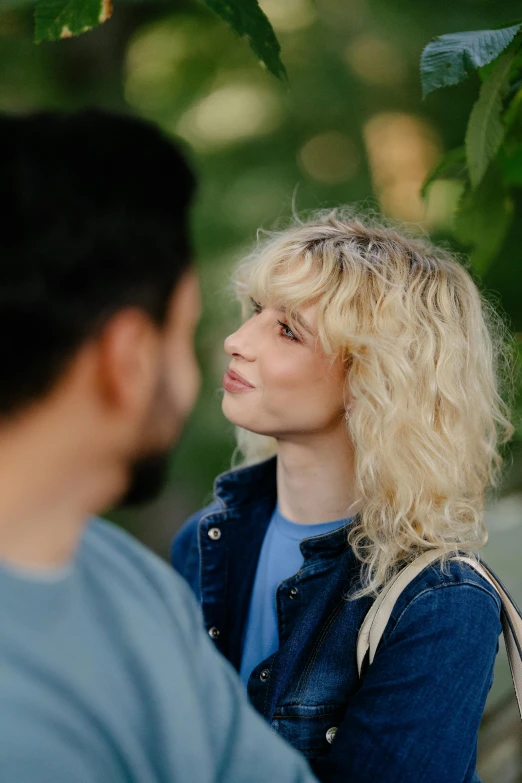 a woman talking to a man in a park
