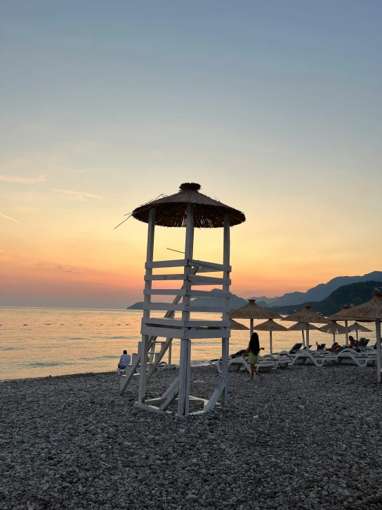 some umbrellas on the beach chairs and water