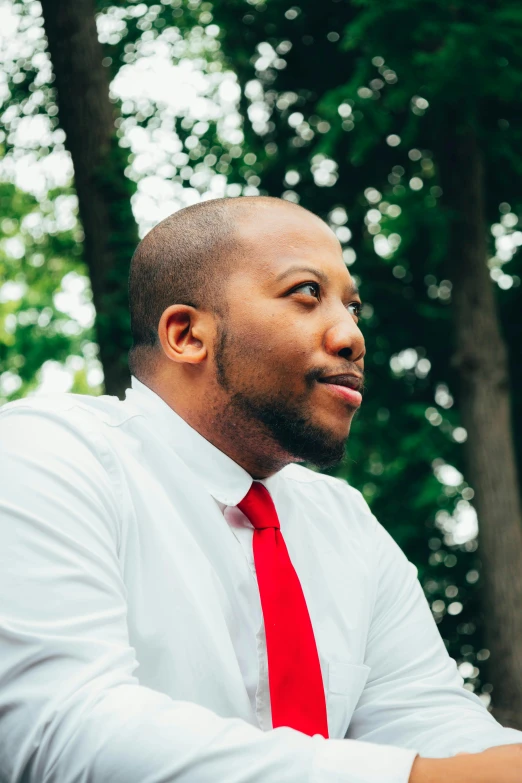 a close up of a person wearing a white shirt and red tie