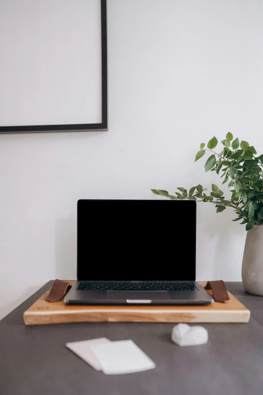 a laptop sits on top of a wooden desk