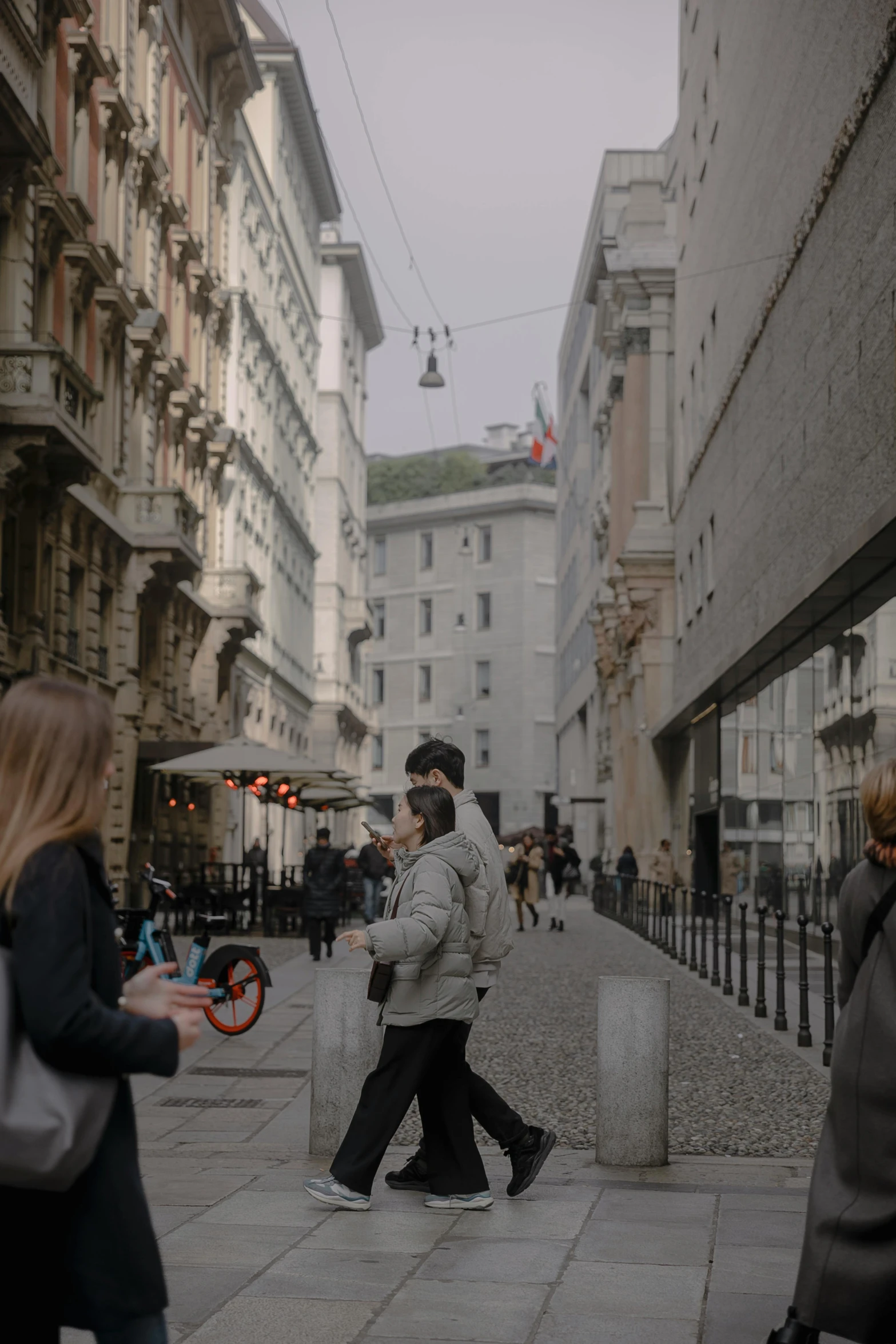 some people walking down an old street in the city