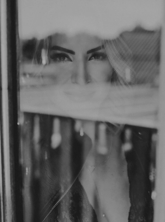 a black and white po of the reflection of a woman's face in a mirror