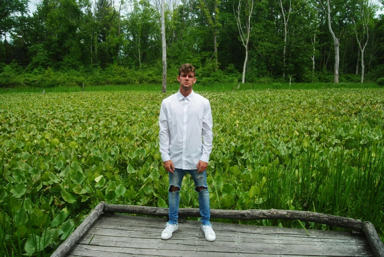 the man in the white shirt stands on the edge of the bridge