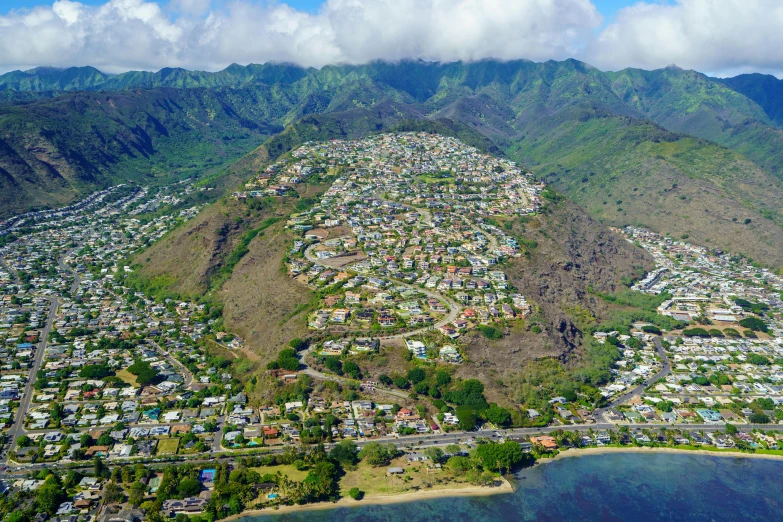 an aerial view of town and mountains with clouds in the sky