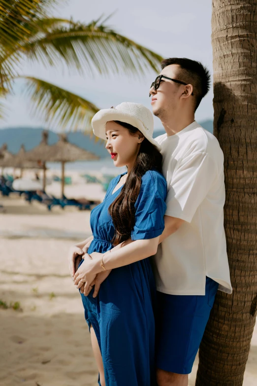 a man hugging the back of his girlfriend on a beach