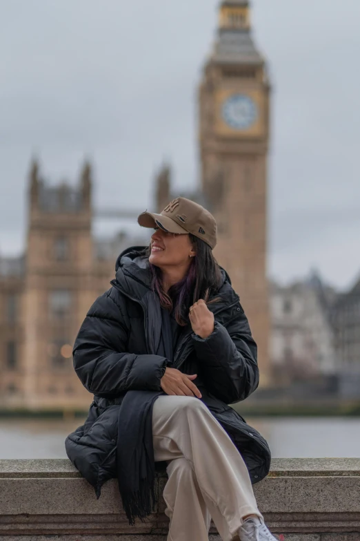 a woman sitting on a ledge looking at the view