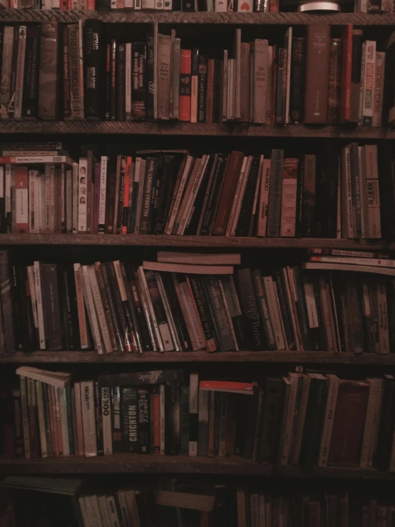 a bookshelf is full of books and has several red ones