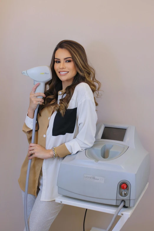 a woman standing in front of a hair dryer