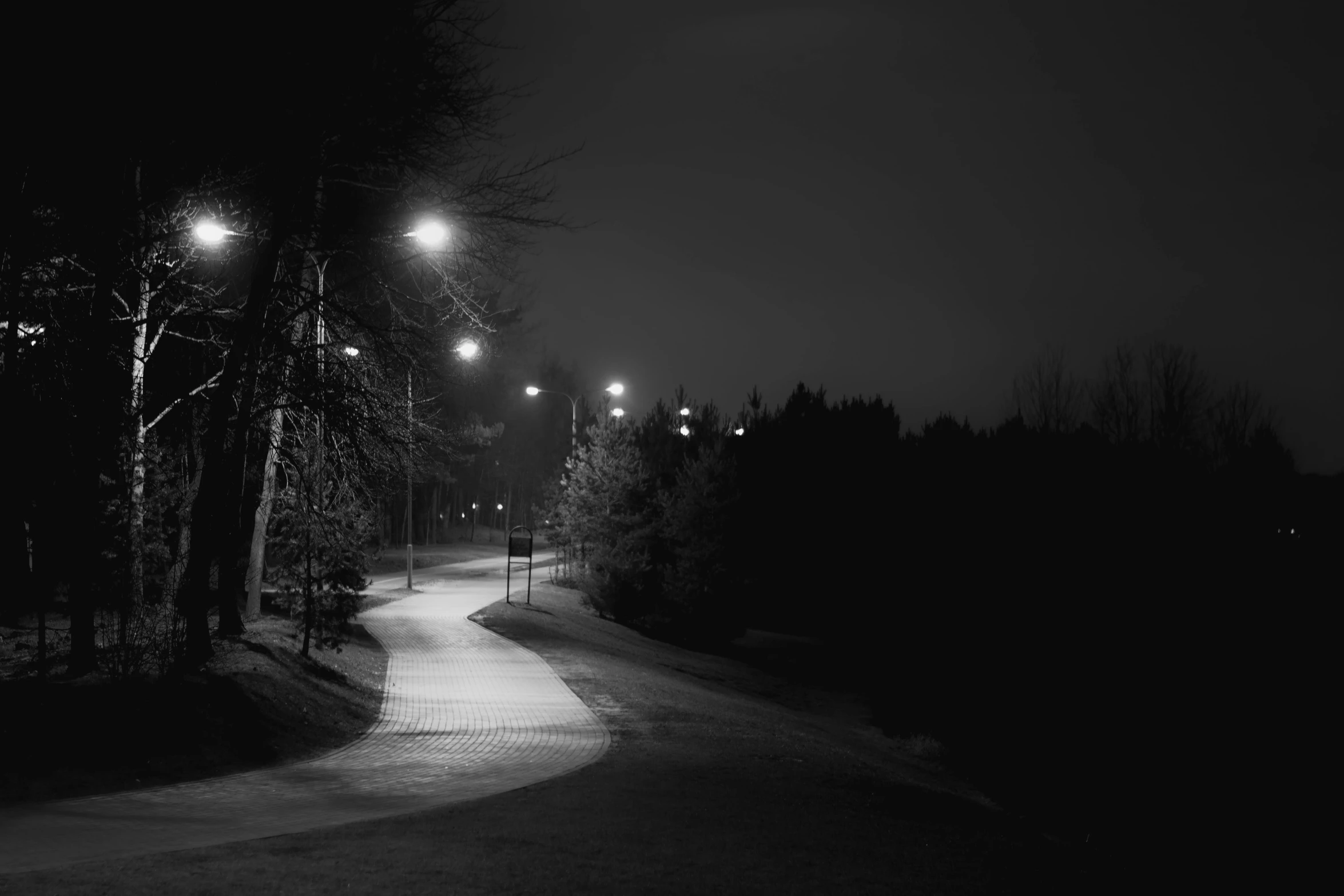 a dark street with several light on it at night