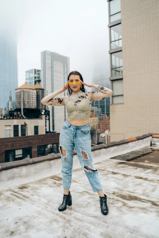 a woman holding her arms out with a view of a city behind her