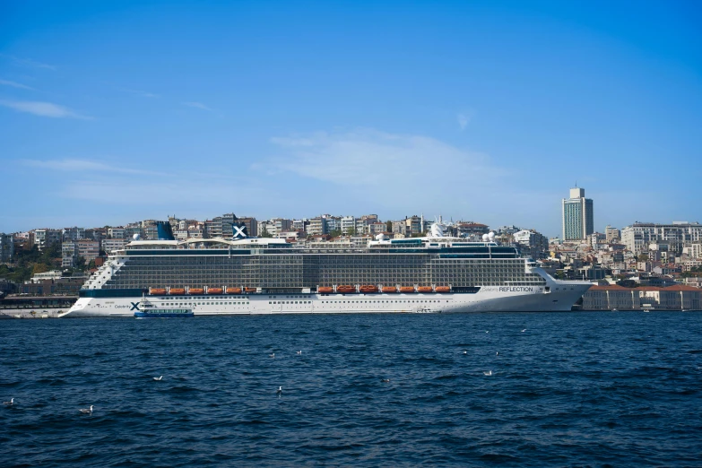 large ship floating on water with city skyline in background