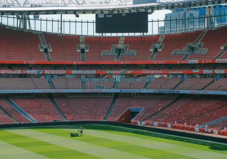 a man on a lawn mower in an empty stadium