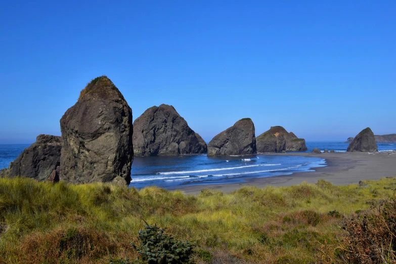 two large rocks are standing out on the beach