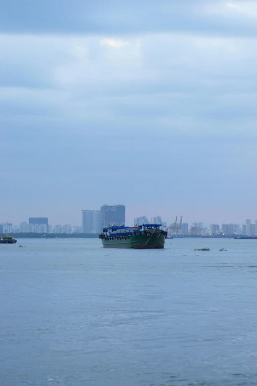 an empty boat floating on top of a lake next to tall buildings