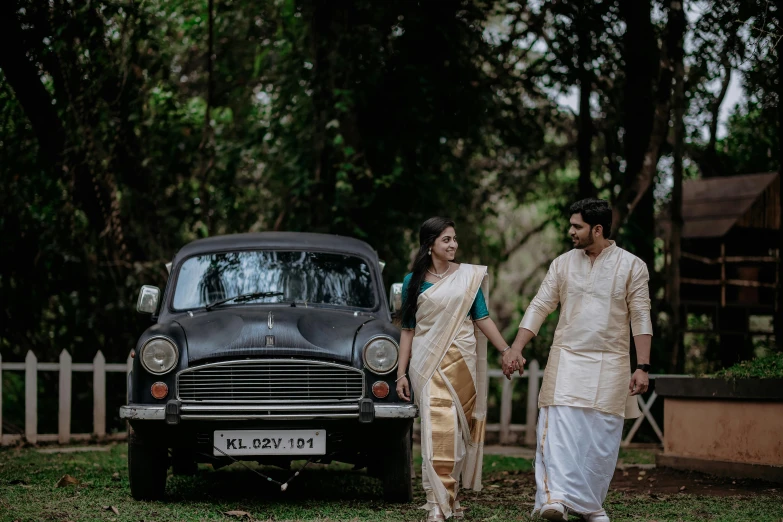 couple with sari standing in front of old classic car