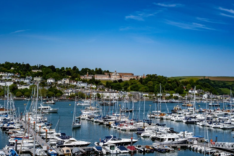 a number of boats in the water near a hill