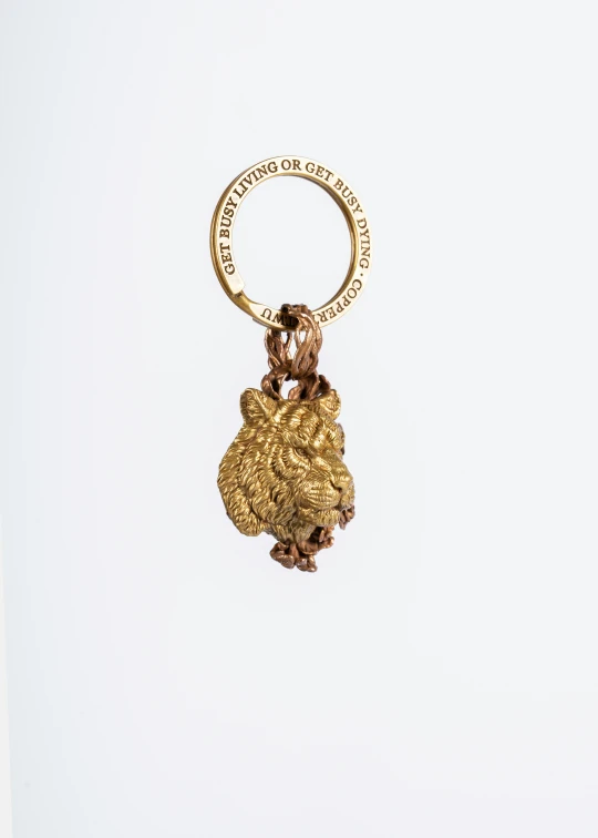 a golden monkey shaped key ring with an inscription that says good luck