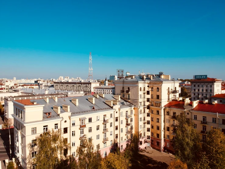 the sky is bright blue over some buildings and an antenna