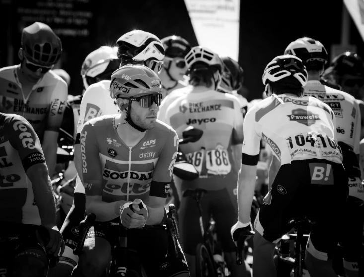 a group of cyclists gather on a street