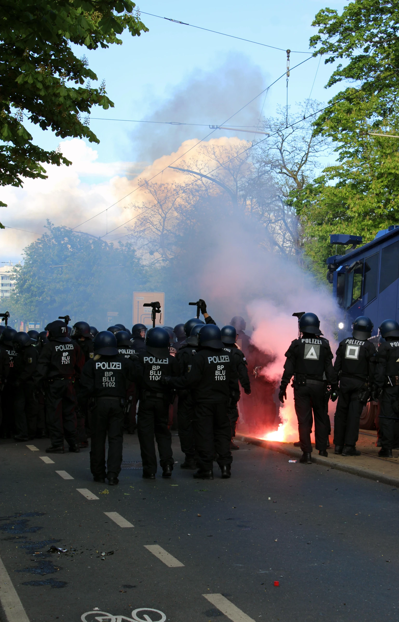 a bunch of policemen watching a fire in the street