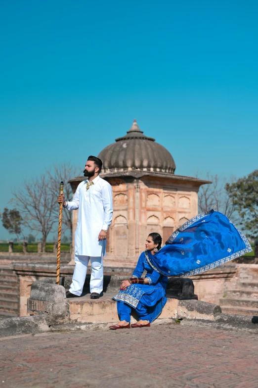 a man in a turban is next to a woman and a small tree