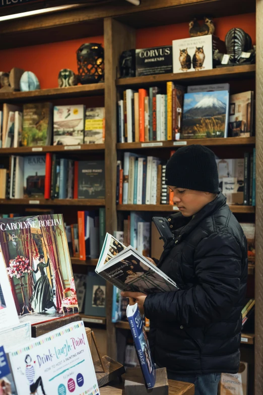 a man reading in front of a bookstore shelf with books