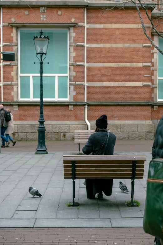 two people sitting on a bench in front of a building