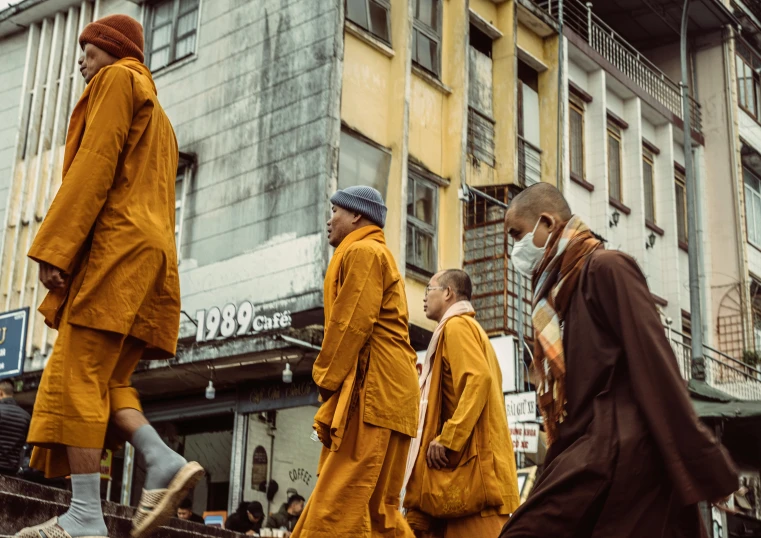 a group of people in orange robes walk in a group