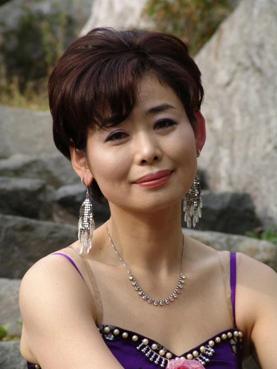 a young woman wearing a necklace and large earrings