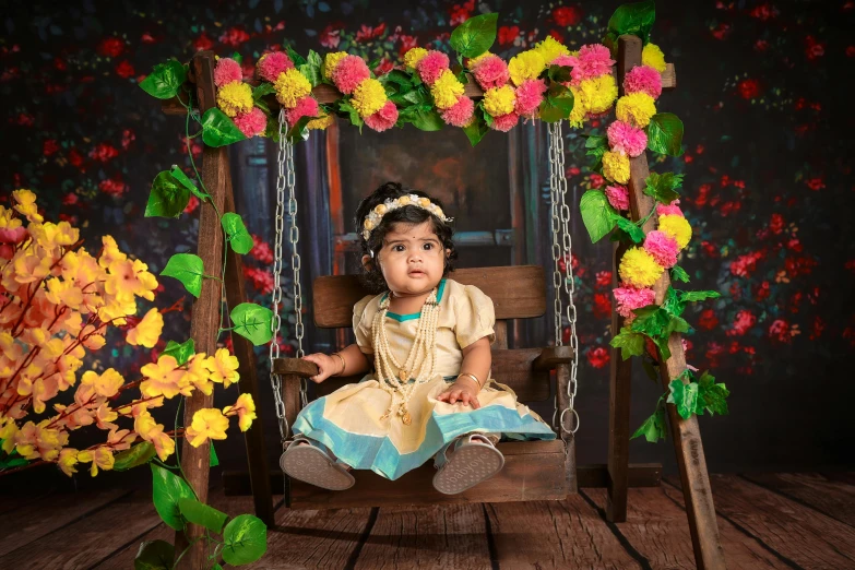 an adorable little girl sitting on a swing surrounded by flowers