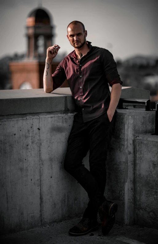 a man leaning on a wall and posing for a po