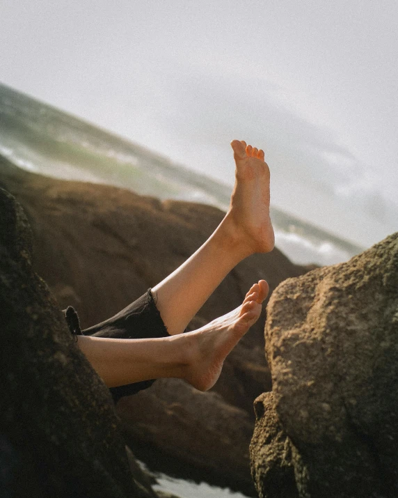 the feet of a person lying on some rocks