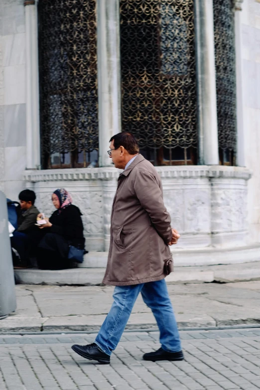 two people walking down the street past a building