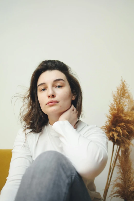 a woman sitting on the floor in front of a wall